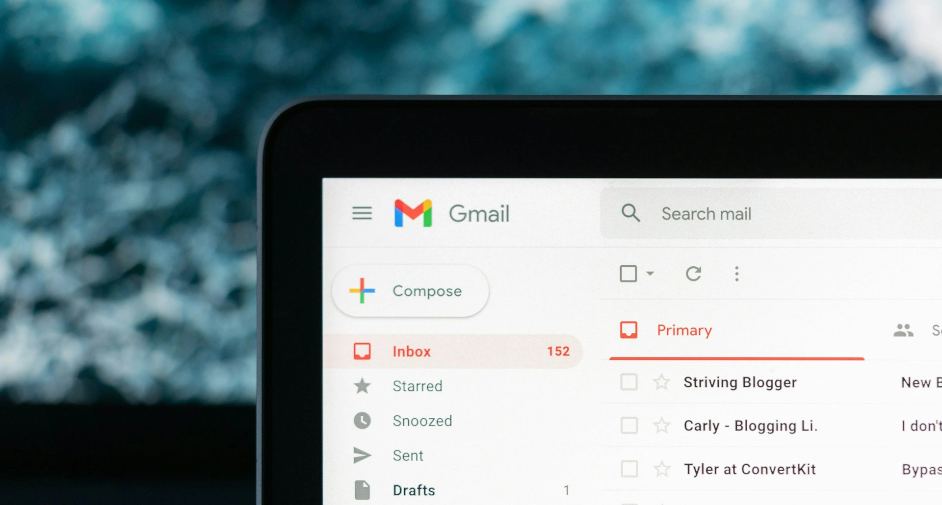 Close-up of a tablet screen displaying the Gmail interface with an unread count of 152 in the Inbox.