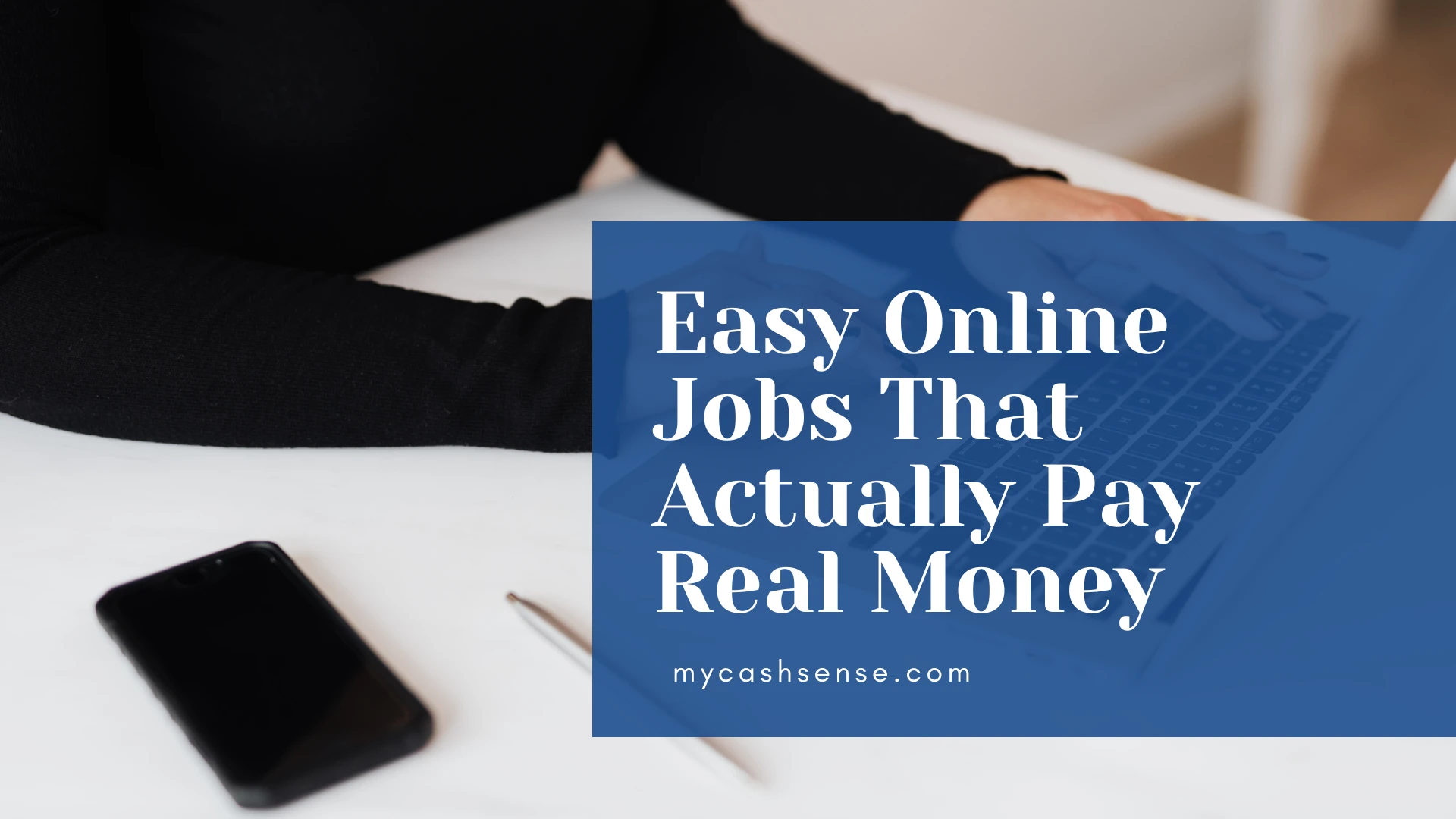 Close-up of a person in black working on a laptop with a smartphone nearby, overlaid with a blue banner reading "Easy Online Jobs That Pay Real Money mycashsense.com".